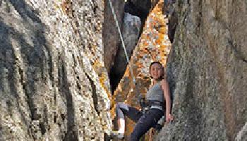 Woman posing in a crevass while climbing.